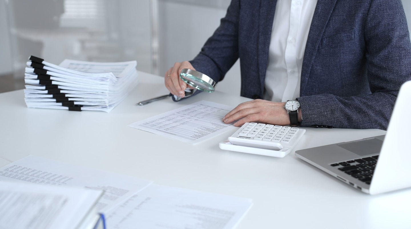 Gros plan sur smartphone tenu en main affichant une application bancaire mobile française avec liste de transactions récentes et solde positif, dans un contexte de vérification de dossier de prêt immobilier